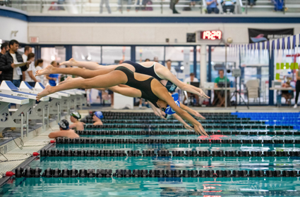 Swimmers coming off the block at a swim meet 